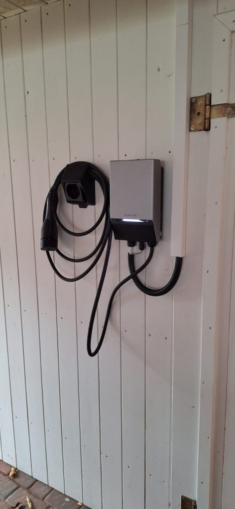 Wallbox mit Ladekabel an einer Hauswand montiert